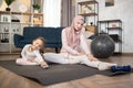 Young muslim mother in hijab showing her little daughter legs stretching exercises. Royalty Free Stock Photo