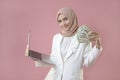 Young muslim woman hold money and laptop on isolated background Royalty Free Stock Photo