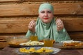 A young Muslim woman in a light khimar at the table says bismi llah before Iftar Ramadan Royalty Free Stock Photo