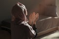 Young Muslim woman praying at home