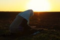 Young Muslim woman praying outdoors at sunrise Royalty Free Stock Photo