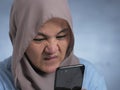 Young Muslim Woman Shocked Expression, Looking at Her Phone Royalty Free Stock Photo