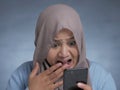 Young Muslim Woman Shocked Expression, Looking at Her Phone Royalty Free Stock Photo