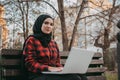 Young muslim woman typing on laptop