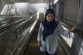 Young Muslim woman using escalator. Lifestyle and technology concept. Royalty Free Stock Photo