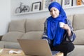 Young Muslim woman using her laptop. Working from home, studying online, browsing the Internet Royalty Free Stock Photo