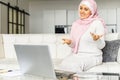 A young muslim woman wearing hijab using a laptop for video call at home Royalty Free Stock Photo