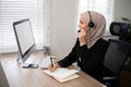 Young muslim women wearing hijab telemarketing or call center agent with headset working on support hotline at office Royalty Free Stock Photo