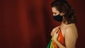 Young naked woman in black protective mask holds large rainbow flag Royalty Free Stock Photo