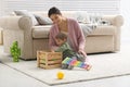 Young nanny and cute little baby playing with toys