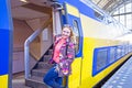 Young native dutch woman getting on a train in Amsterdam