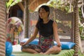 Young natural and attractive Asian Chinese woman practicing yoga and meditation exercise sitting lotus pose outdoors at beautiful Royalty Free Stock Photo