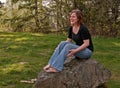 Young Natural Looking Woman Laughin While Sitting on Rock Barefo Royalty Free Stock Photo