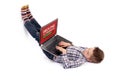 Young nerd boy lying on floor and hacking using a laptop Royalty Free Stock Photo