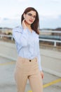 Young nerd businesswoman talking by hands free device outdoors Royalty Free Stock Photo