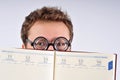 Young nerd hiding behind agenda Royalty Free Stock Photo