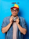 Young nerd man with noob hat holding camera