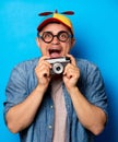 Young nerd man with noob hat holding camera