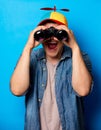 Young nerd man with noob hat using a binoculars