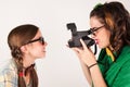 Young nerdy girls using instant camera. Royalty Free Stock Photo