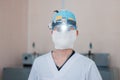 Young neurosurgeon man in glasses with binary loupes for microsurgery with light in the operating room. Modern medicine.