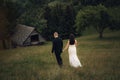 Young newlywed couple walking in a grassy field. Royalty Free Stock Photo