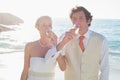 Young newlyweds drinking champagne linking arms