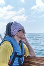 Young nice asian woman in life jacket and sunglasses on pleasure boat on sea. Royalty Free Stock Photo