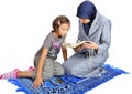 Young nice muslim female teaching her daughter