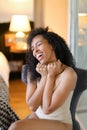 Nice smiling black girl sitting in room and wearing beige lingerie. Royalty Free Stock Photo