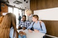 Young nice woman hugging her co-workers and congratulating them with good job Royalty Free Stock Photo