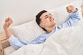 Young non binary man waking up stretching arms Royalty Free Stock Photo