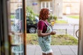 Young non-binary person standing in the doorway of a cafe