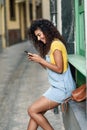 Young North African woman texting with her smart phone outdoors Royalty Free Stock Photo