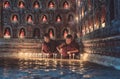 Young novice monks lighting up candlelight inside a Buddhist temple, low light setting, Shan state, Myanmar Royalty Free Stock Photo
