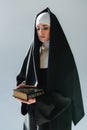 young nun in black cassock holding