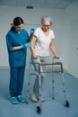 Young nurse accompanies an elderly lady in clinic