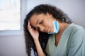 Young nurse or doctor in scrubs leans against wall, overworked stressed