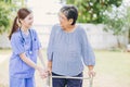 Young nurse helping asian senior woman walking. caregiver assisting old lady patient at nursing home. elder walk with walker at Royalty Free Stock Photo