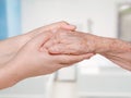 Young nurse holding old patient hand Royalty Free Stock Photo