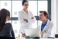 Young nurse listening to an experienced physician while consulting a patient