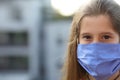 Young nurse with long brown hair and blue surgeon mask