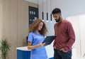 Young nurse talking with patient at reception in private dental clinic.