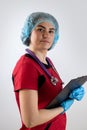 young nurse wearing red uniform with stethoscope hold clipboard isolated on white background Royalty Free Stock Photo