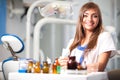 Young nurse woman in white uniform sitting near dental chair in dental office in clinic with equipment at background Royalty Free Stock Photo