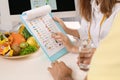 Young nutritionist consulting patient at table in clinic