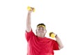 Young obese man lifting dumbbells in the studio