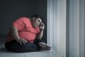 Young obese man looks stressed near the window Royalty Free Stock Photo