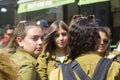 A young off duty female Israeli Army conscript looks way from her group wistfully as they relax together at the Mahane Yehuda stre