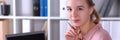 Young office employee sits at desk in front laptop